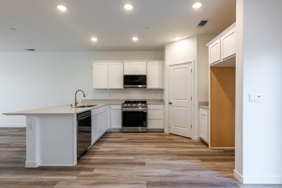 A kitchen with white cabinets.
