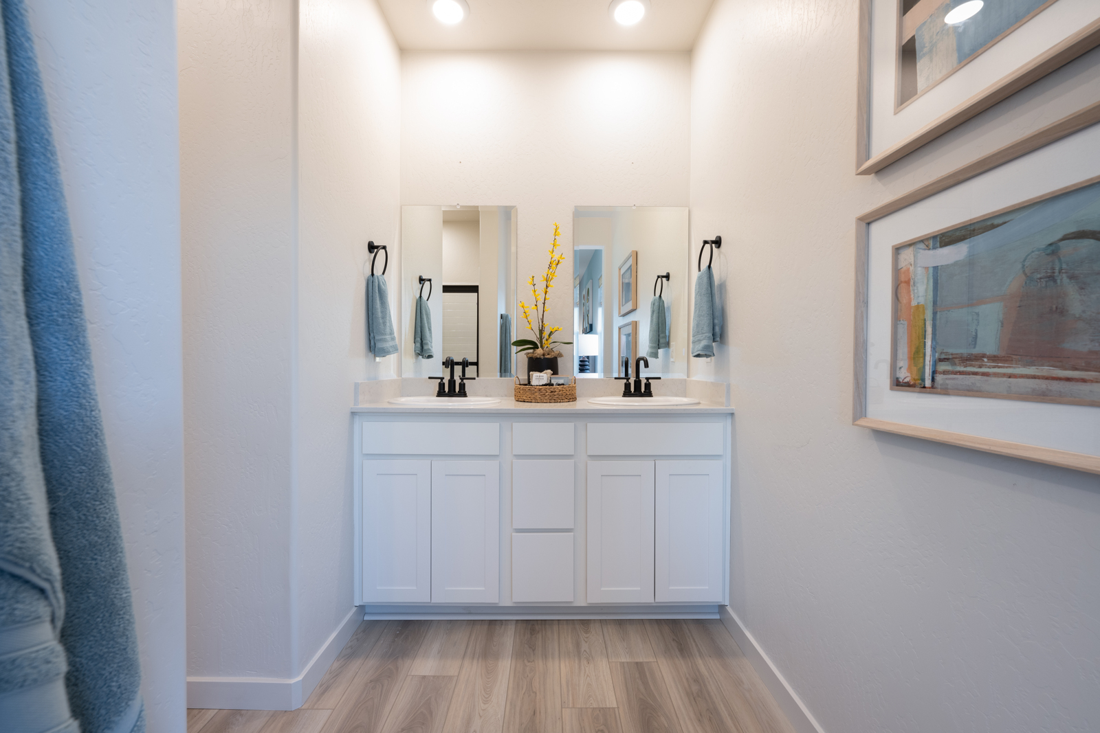 A bathroom with white cabinets.