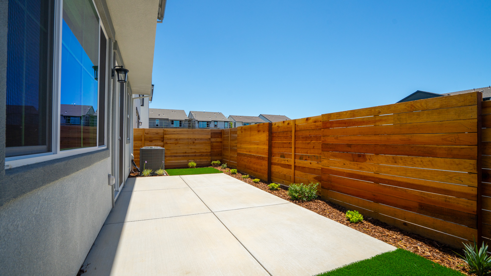 A fenced in yard with a wood fence and a building.