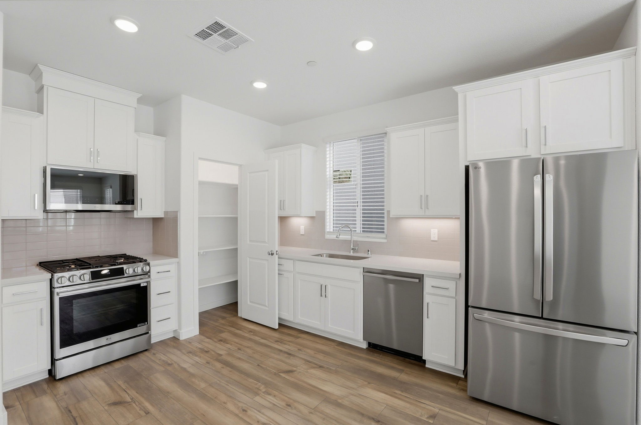 A kitchen with white cabinets.
