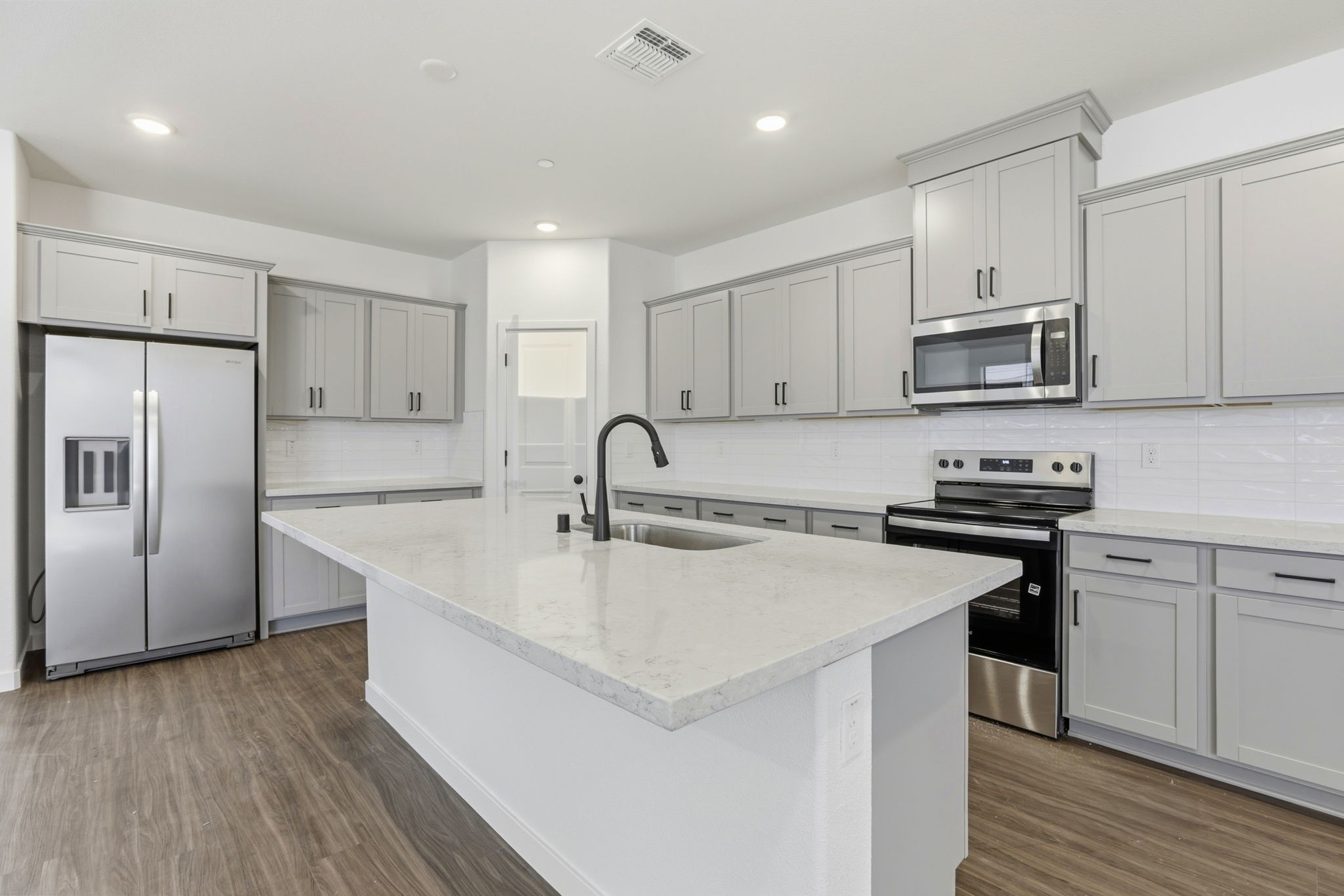 A kitchen with white cabinets.