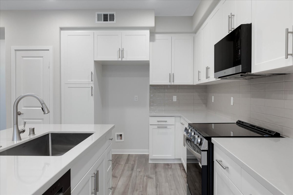 A kitchen with white cabinets.
