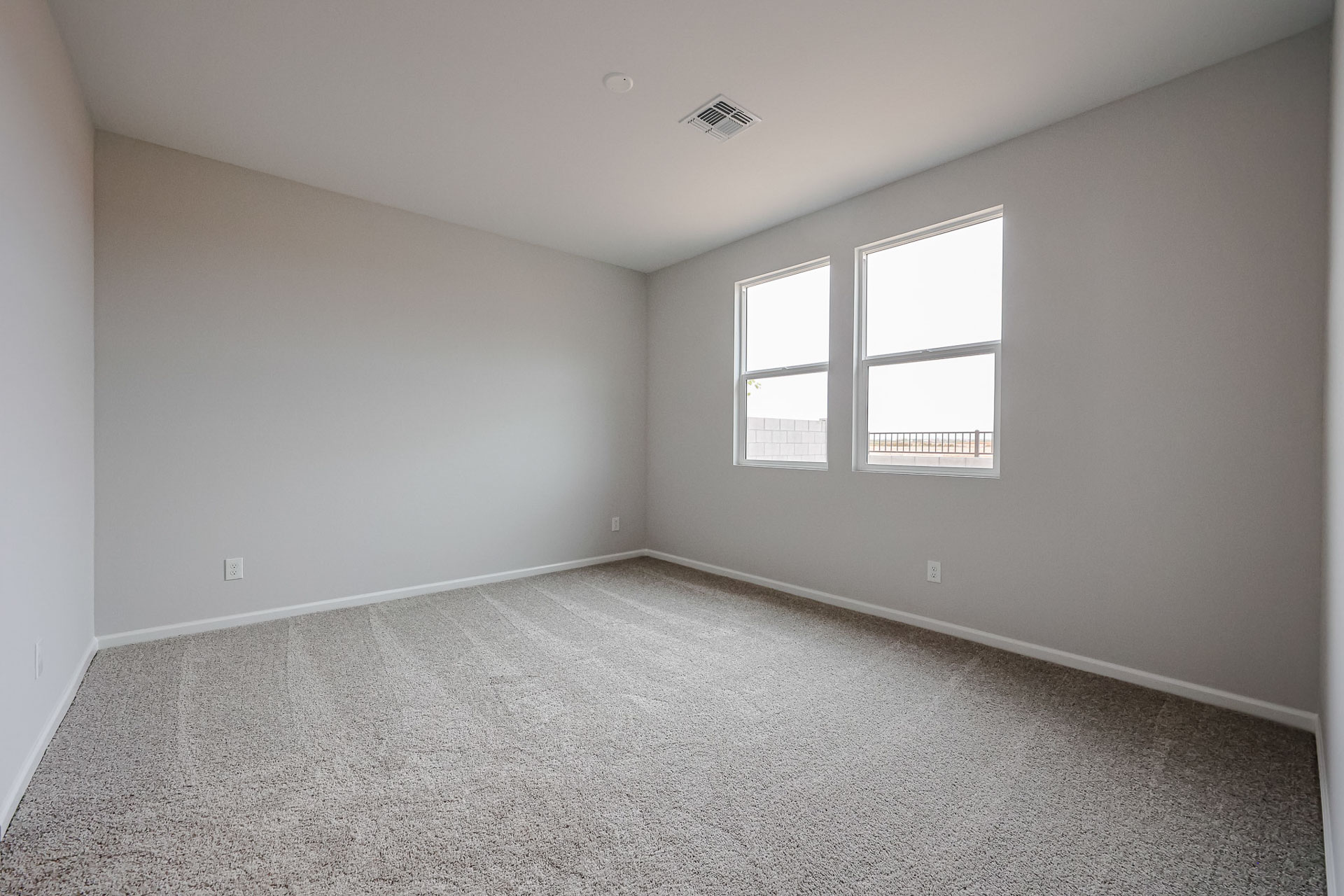 A room with a carpet and windows.