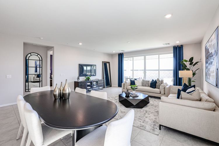 A living room with a large glass table and white chairs.