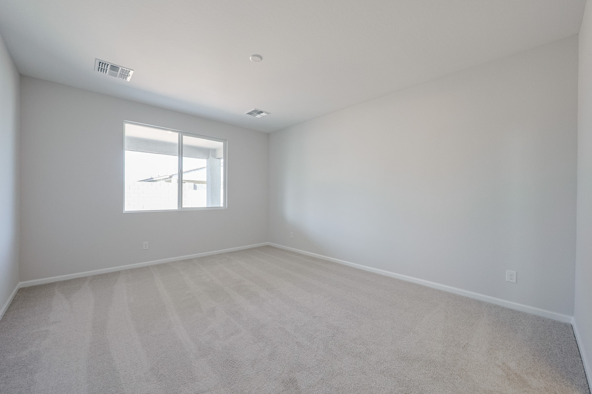 A room with a window and a carpet.