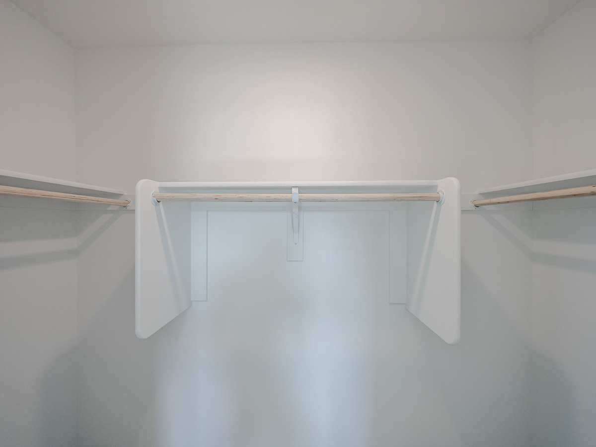 A white shelf with a metal bar.