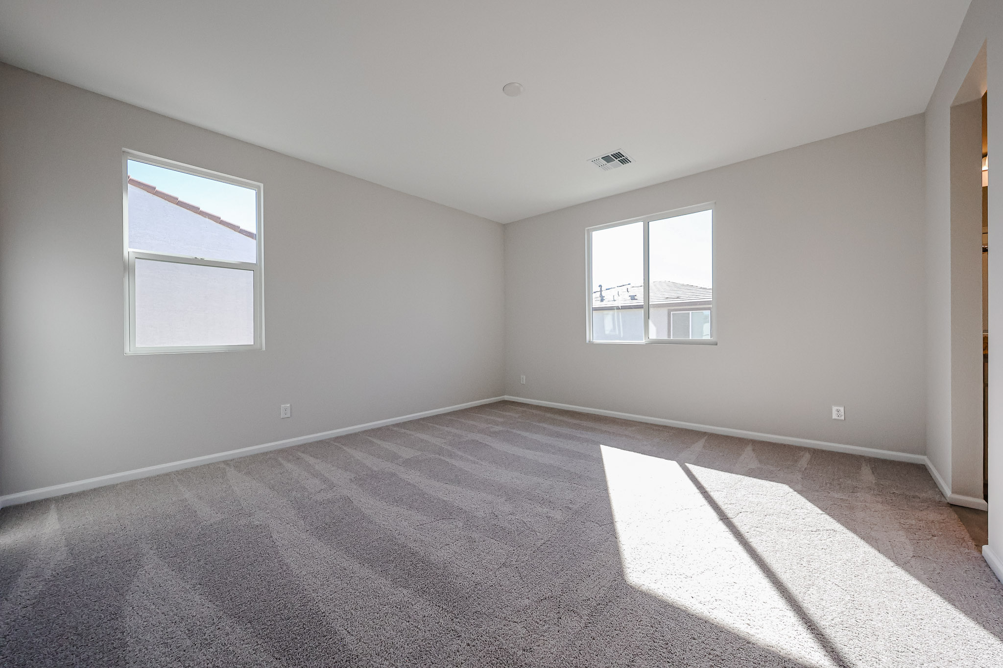 A room with a carpet and windows.