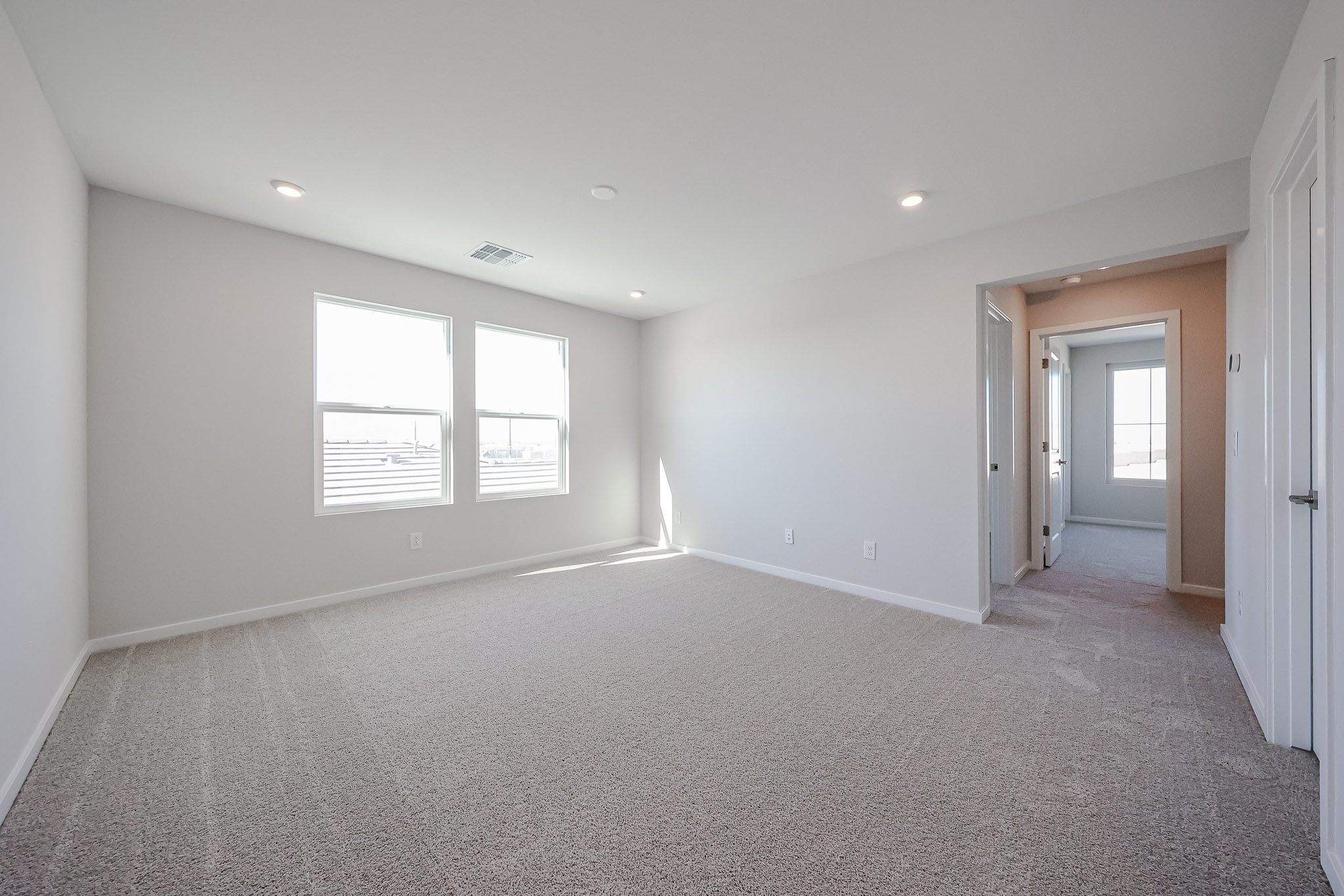 A room with a carpet and windows.