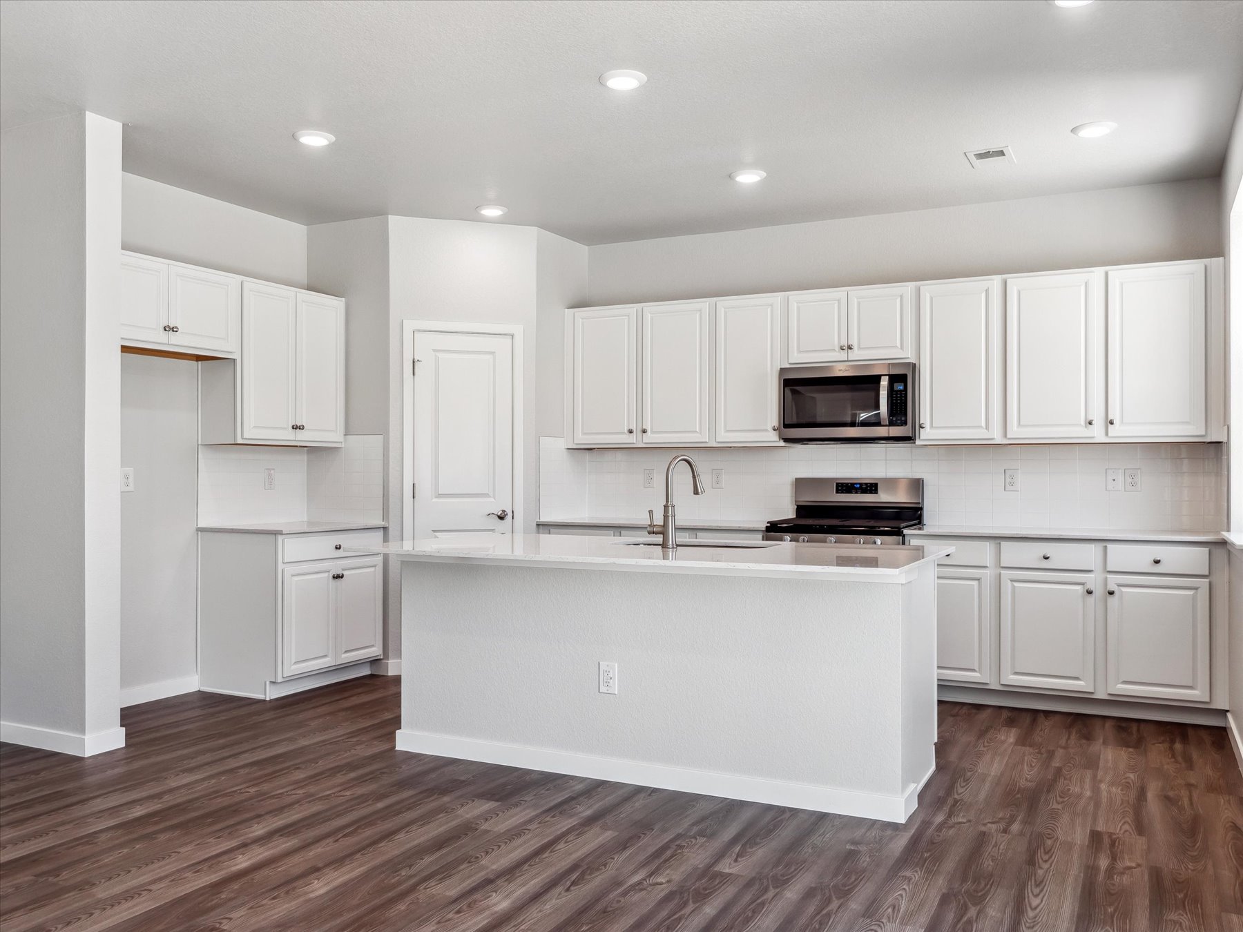 A kitchen with white cabinets.