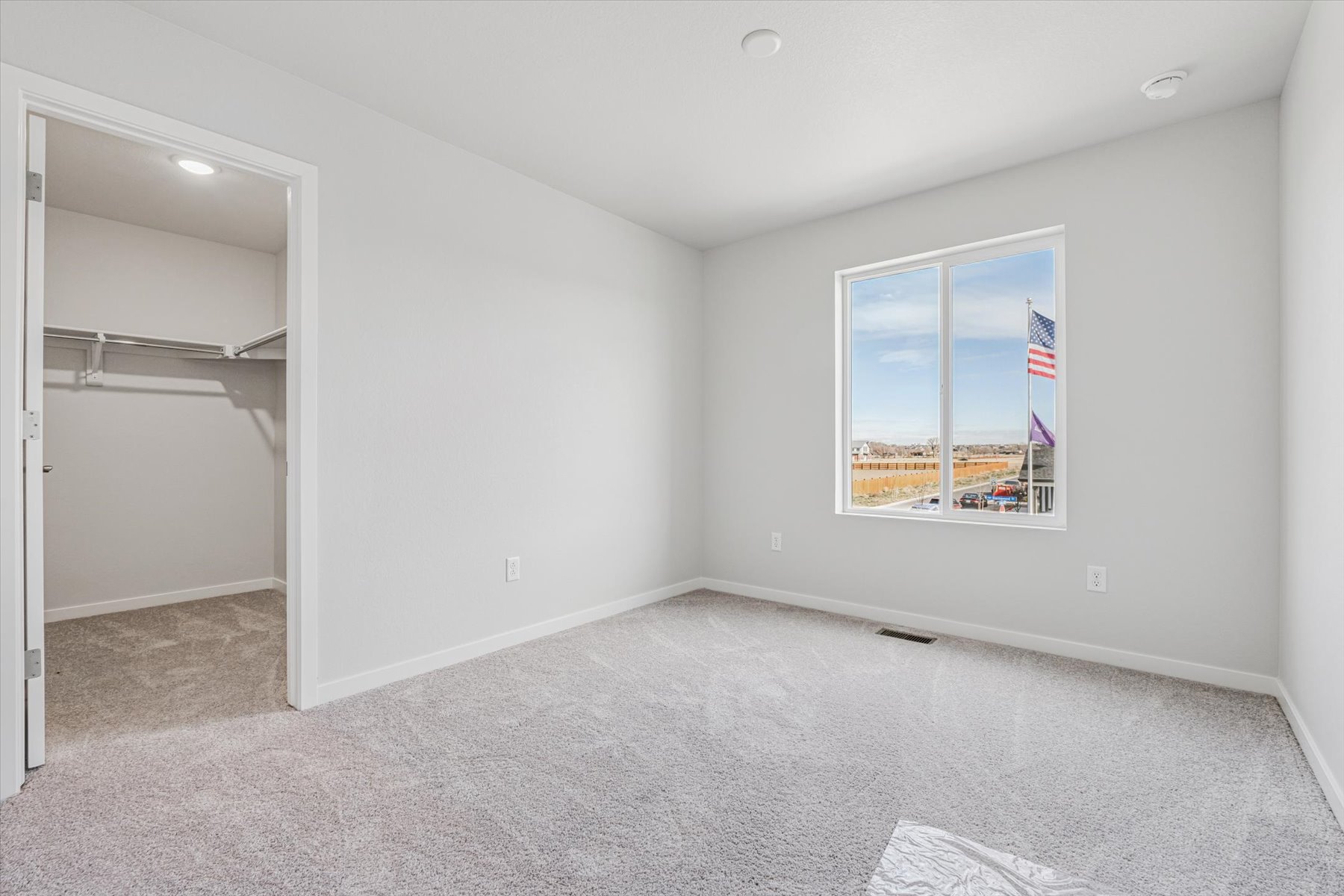 A room with a window and a rug.