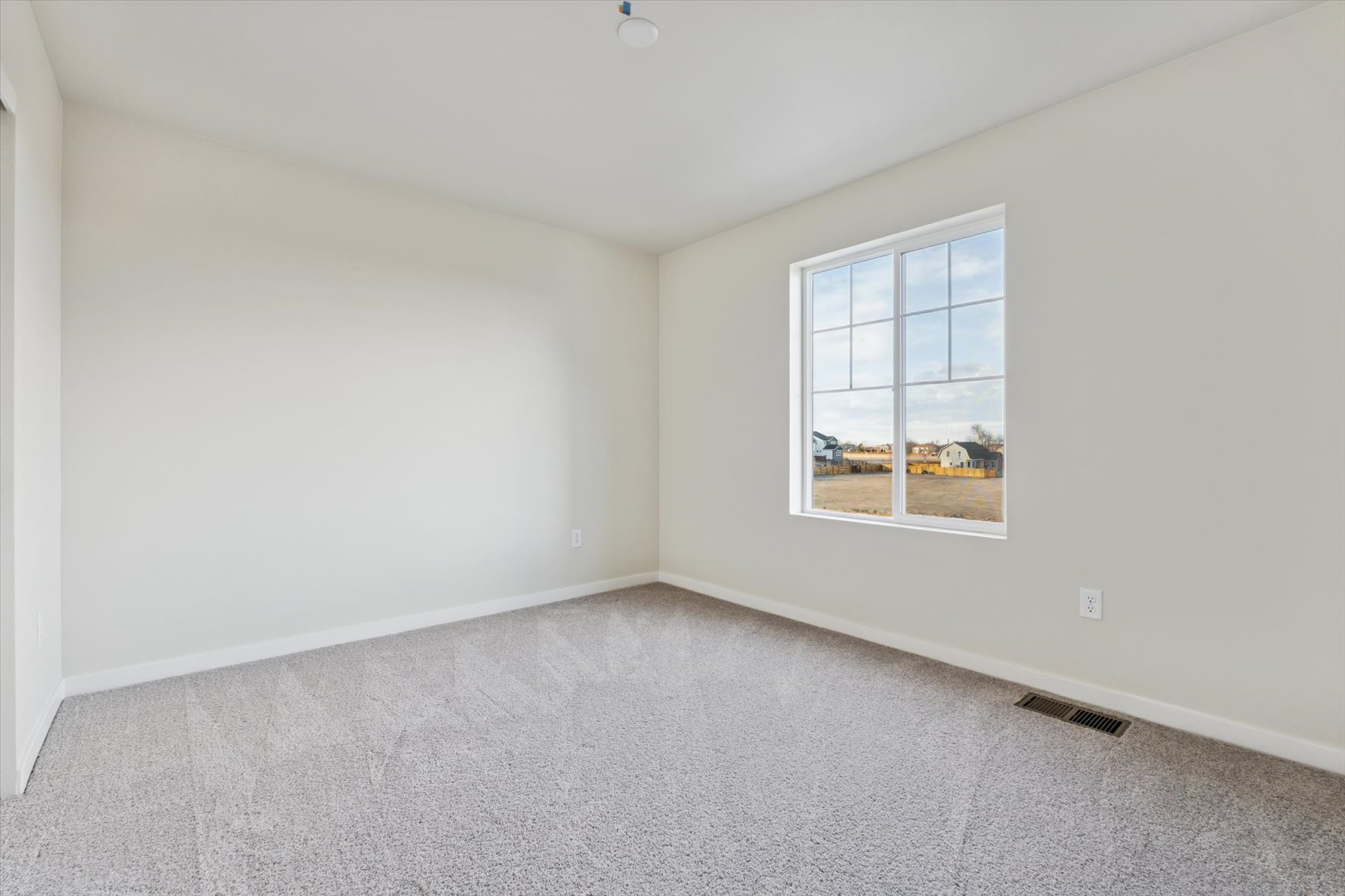 A room with a window and a carpet.