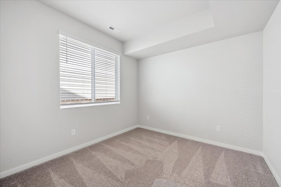 A room with a window and a rug.