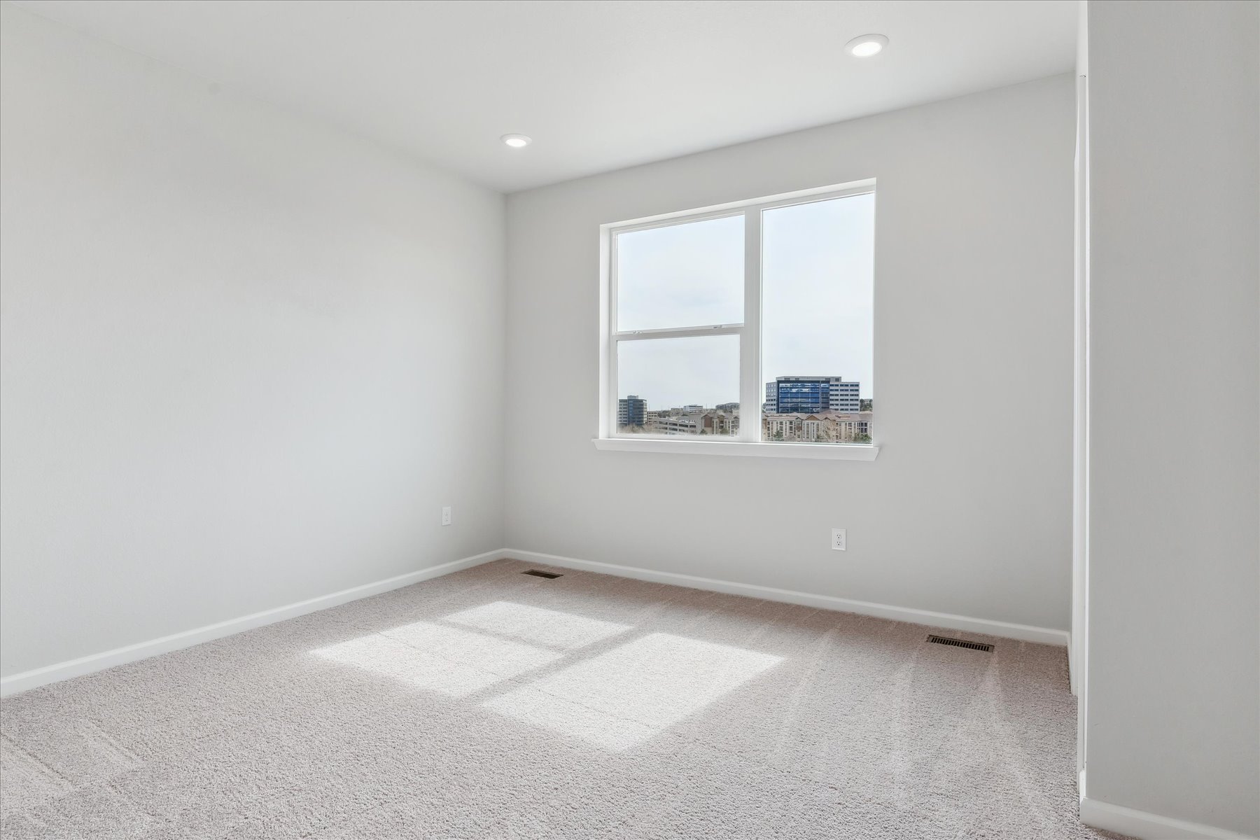 A room with a window and a rug.
