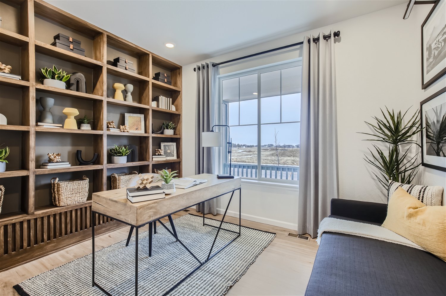 A room with a table and a bookcase with a window.