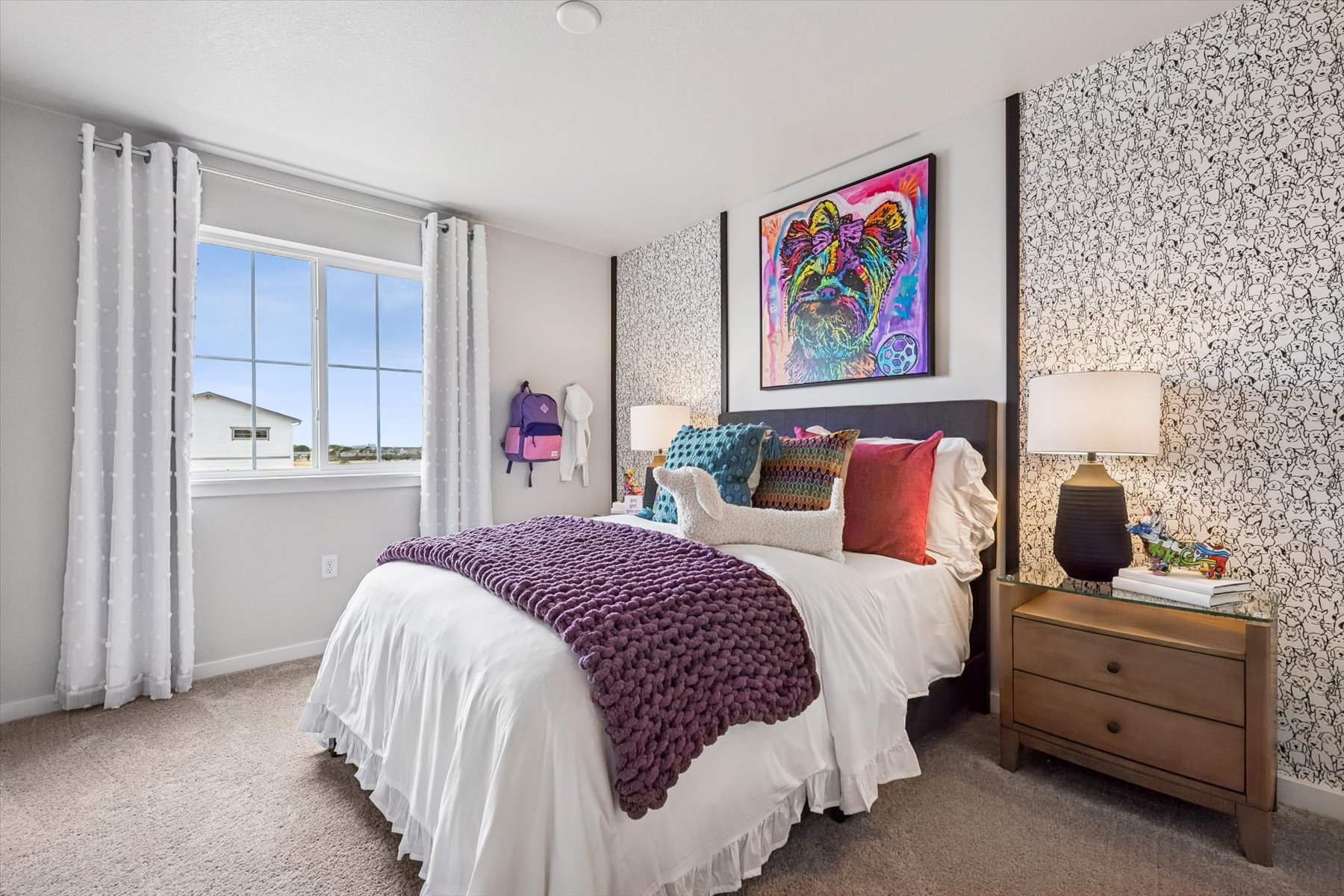 A bedroom with a bed and lamps.