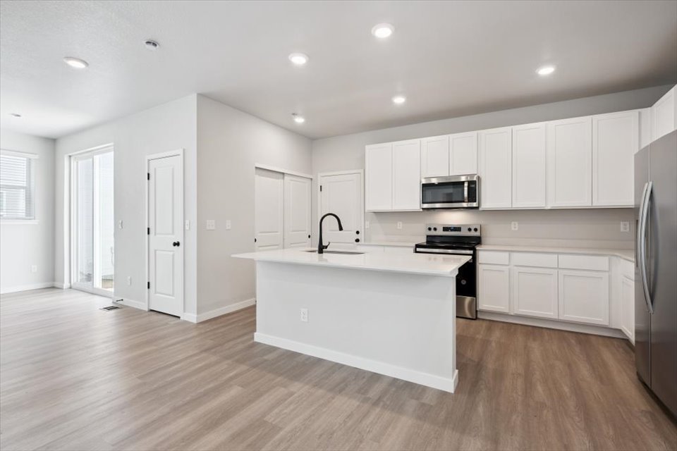A kitchen with white cabinets.