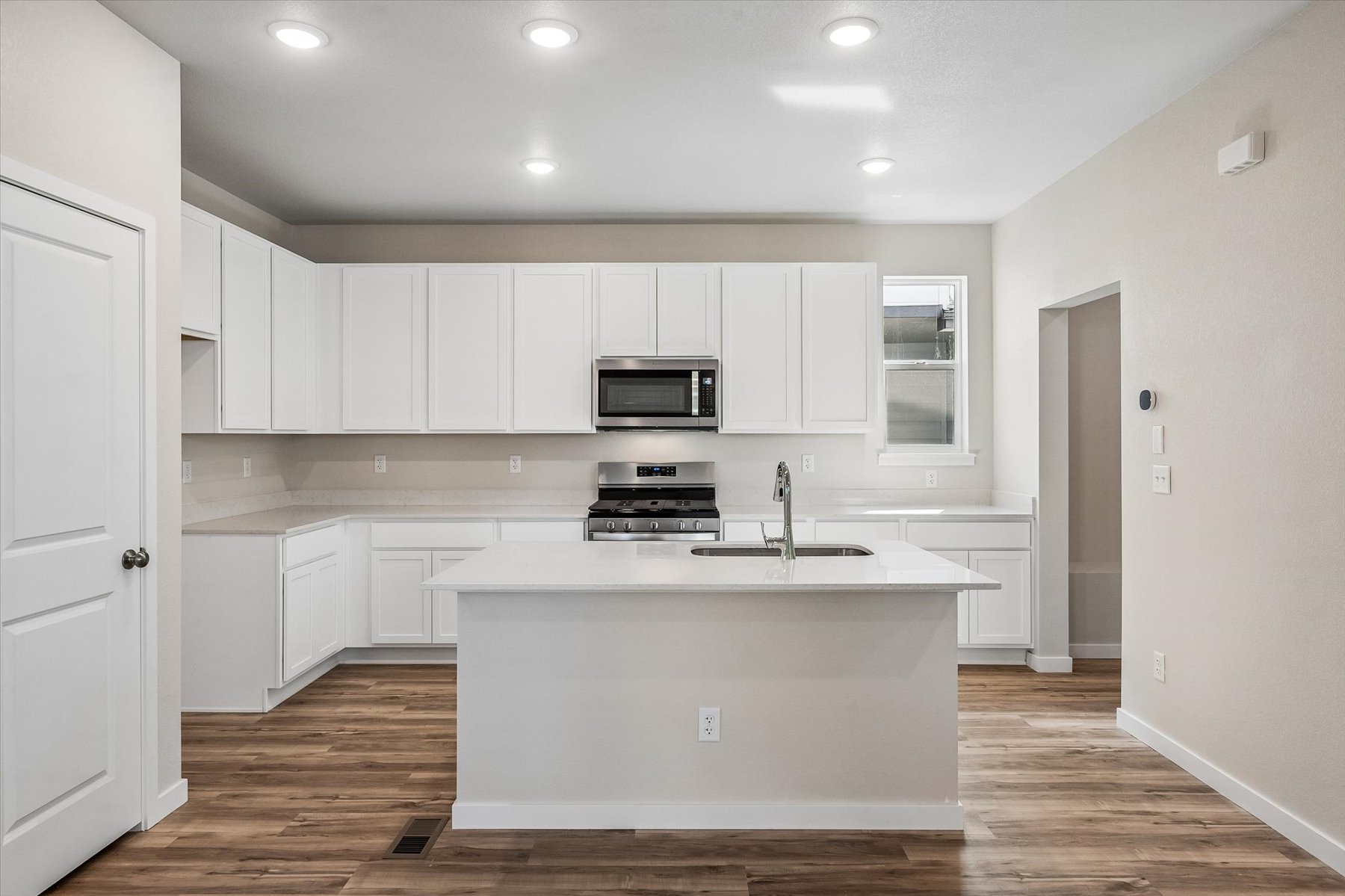 A kitchen with white cabinets.