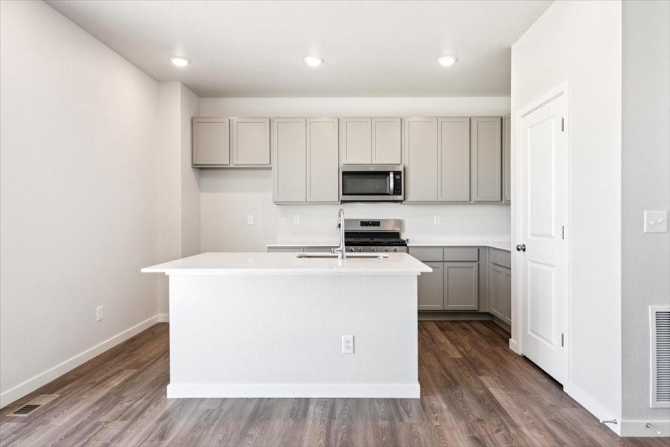 A kitchen with white cabinets.