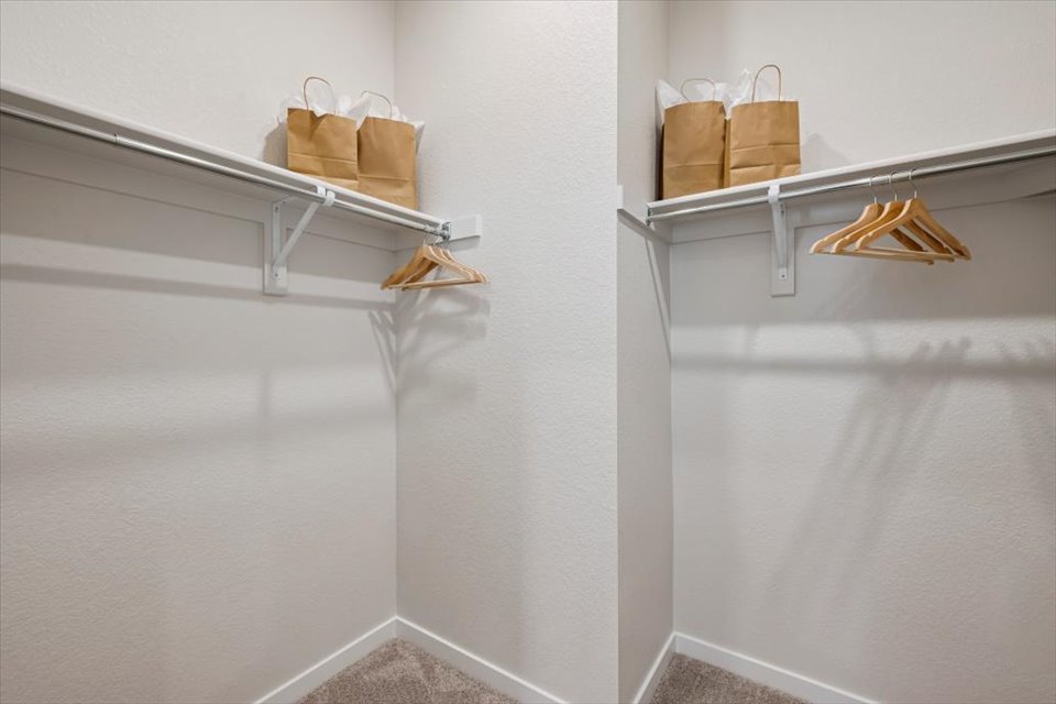 A white shelf with baskets on it.