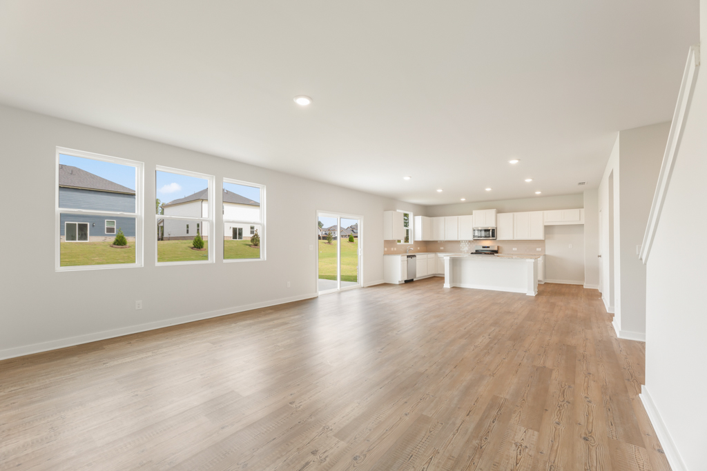 A large empty room with a wood floor and white walls.