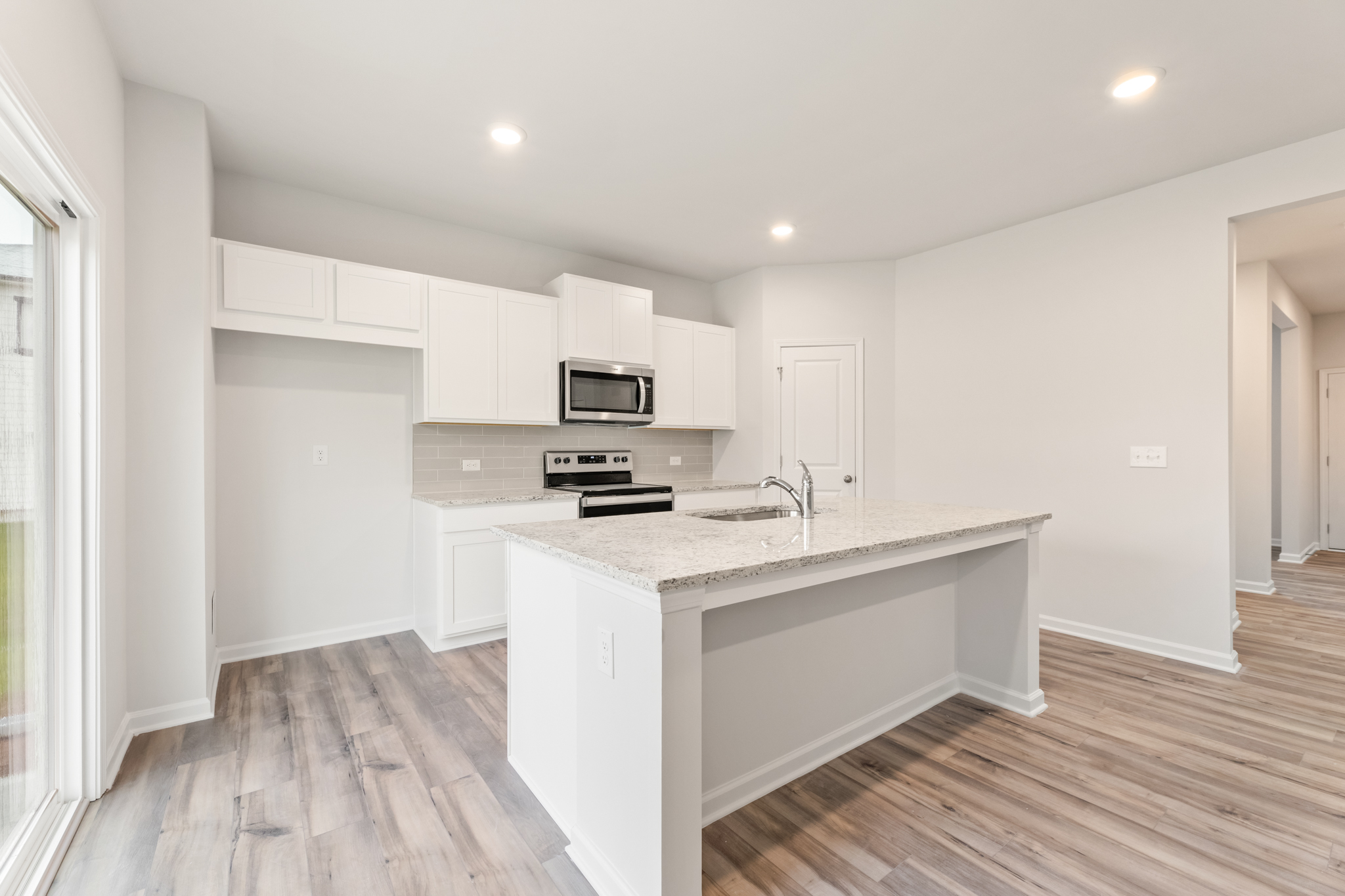 A kitchen with white cabinets.