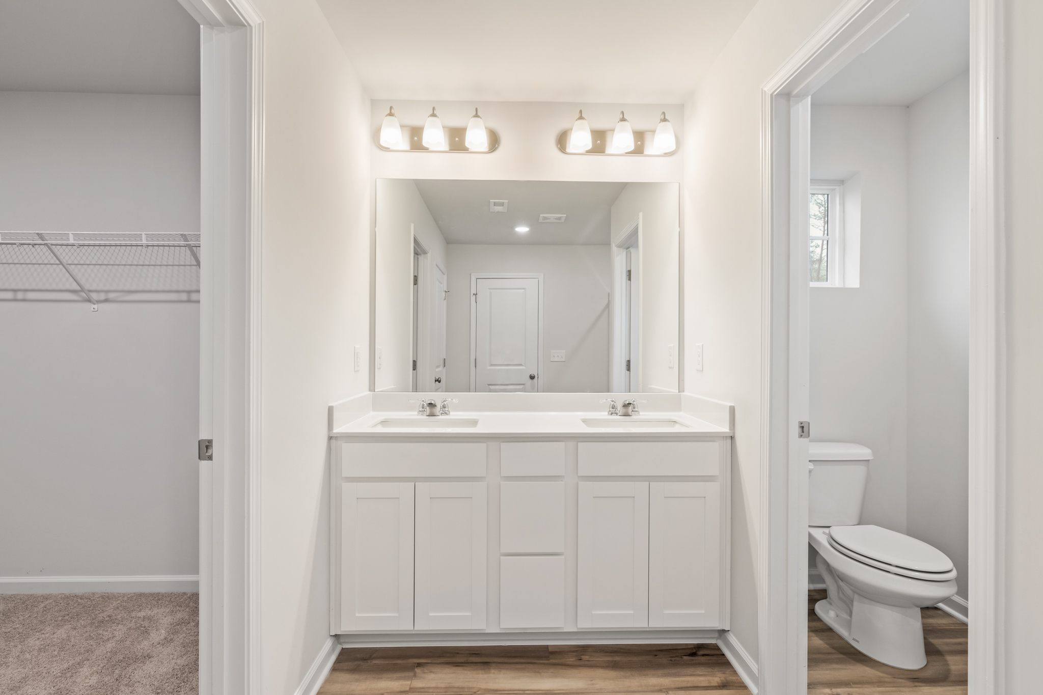 A bathroom with white cabinets.