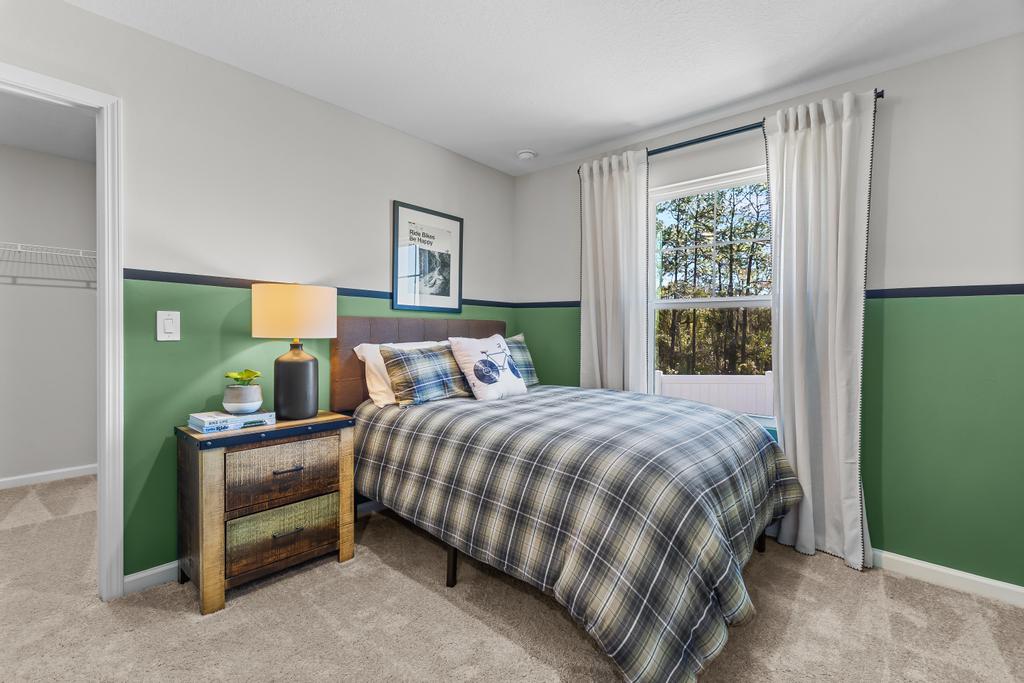 A bedroom with a bed and a lamp.