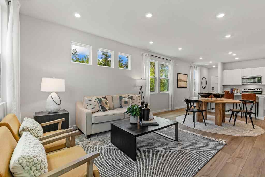A living room with a large rug and a table.