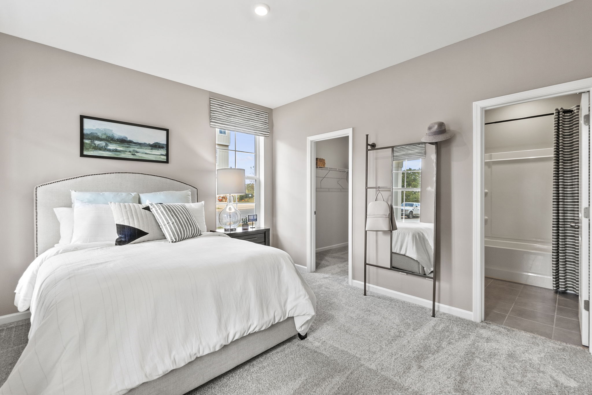 A bedroom with a large mirror.