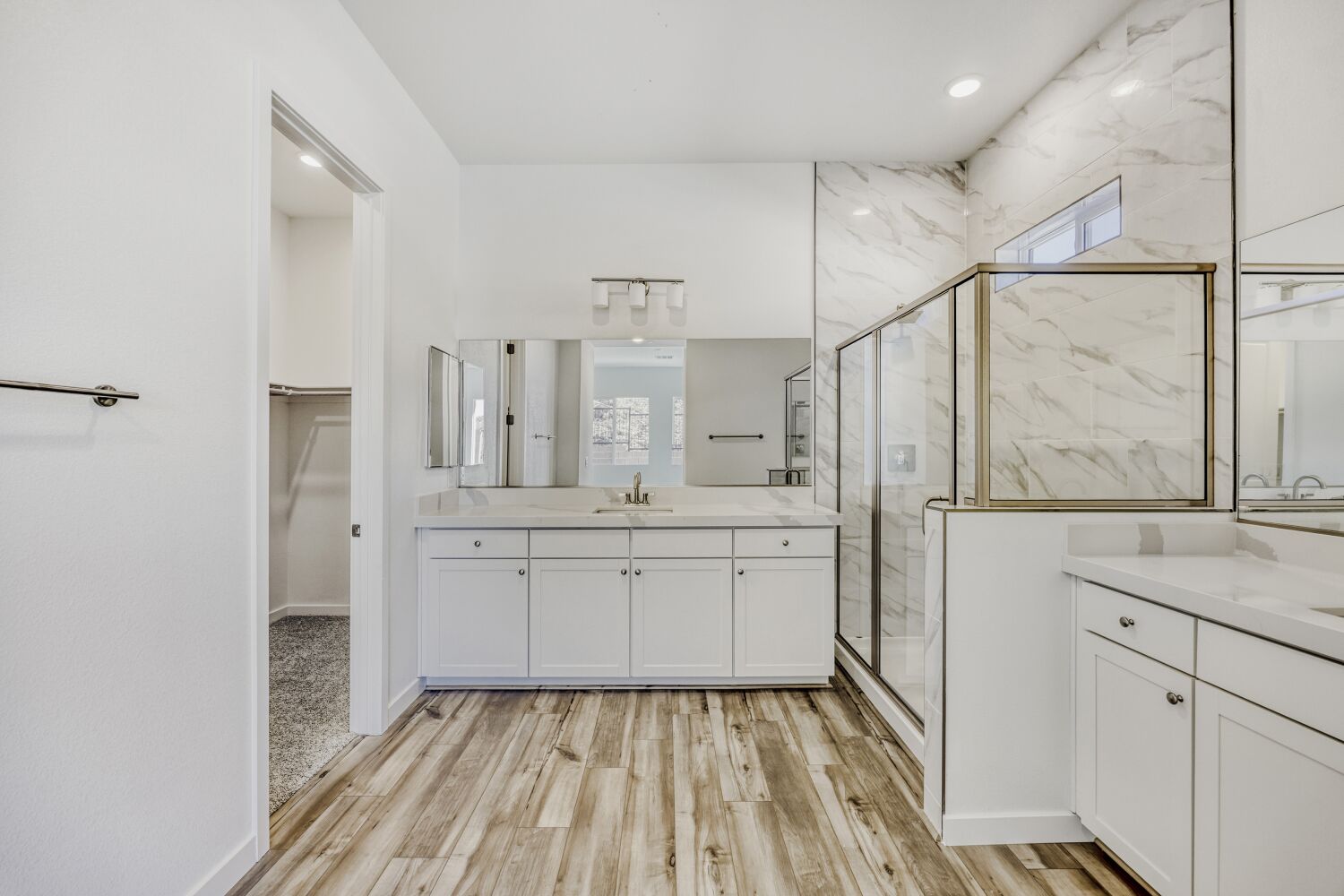 A bathroom with white cabinets.