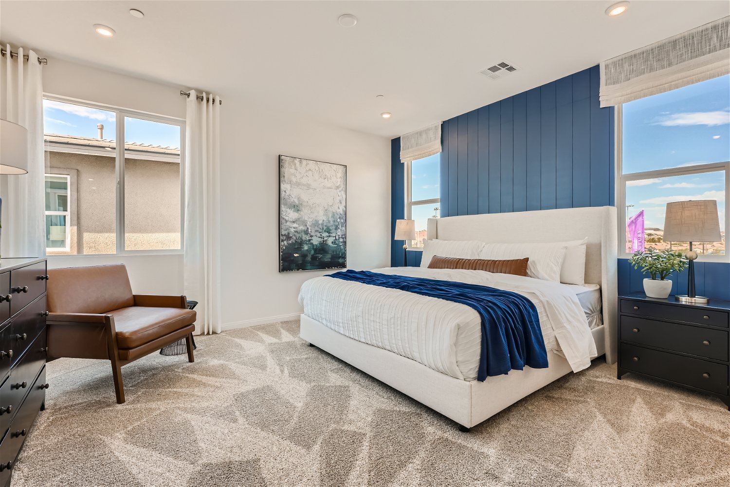 A bedroom with a bed and a chair.