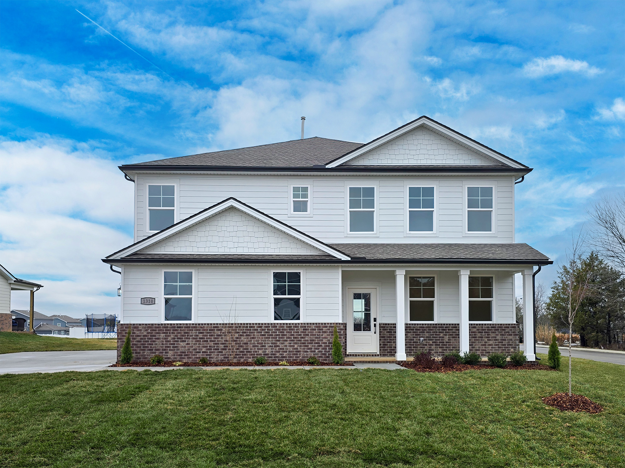 A white house with a lawn in front of it.