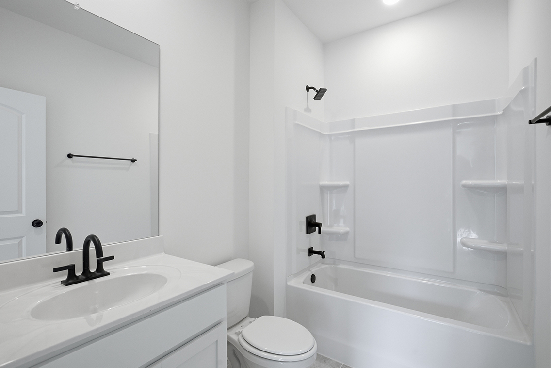 A bathroom with a sink toilet and bathtub.