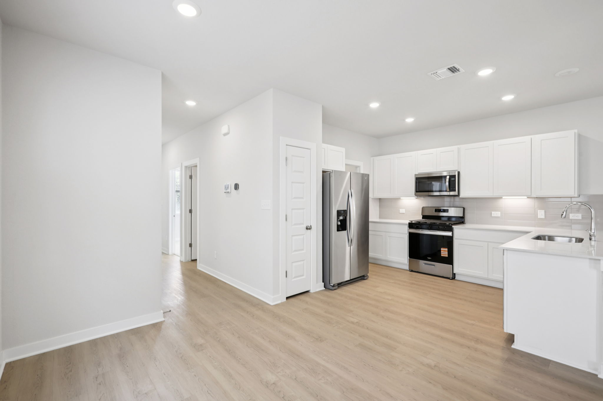 A kitchen with white cabinets.