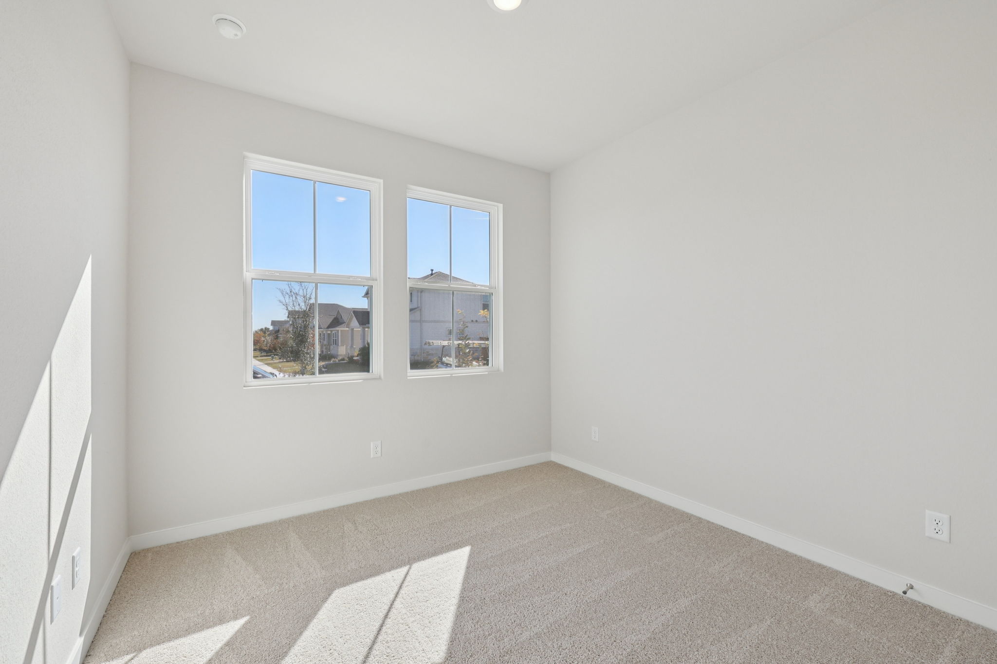 A room with a window and a rug.