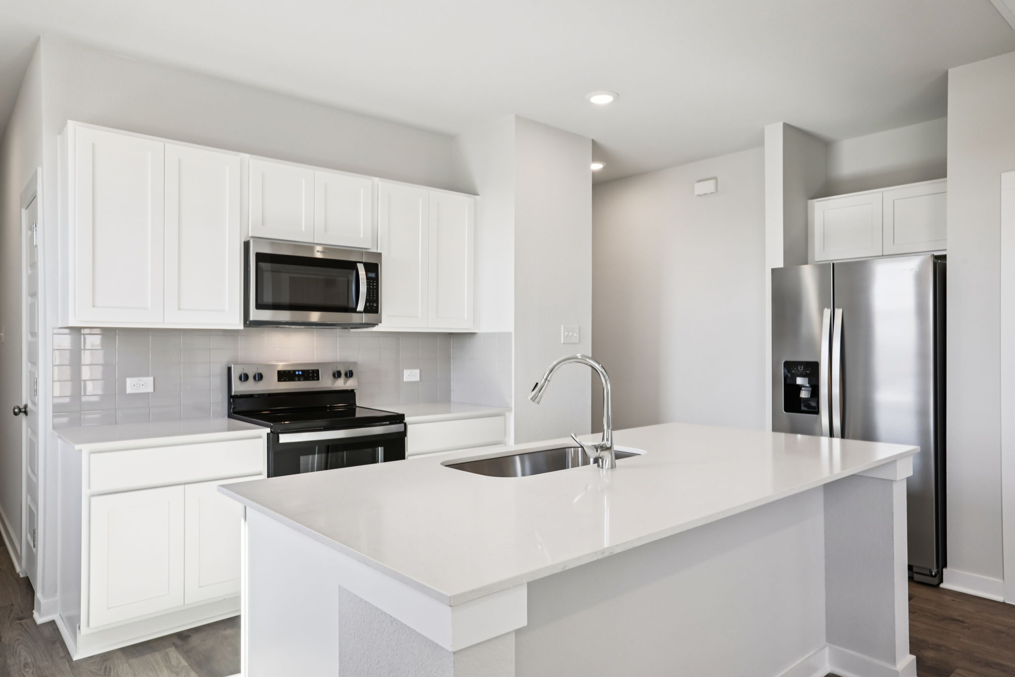 A kitchen with white cabinets.