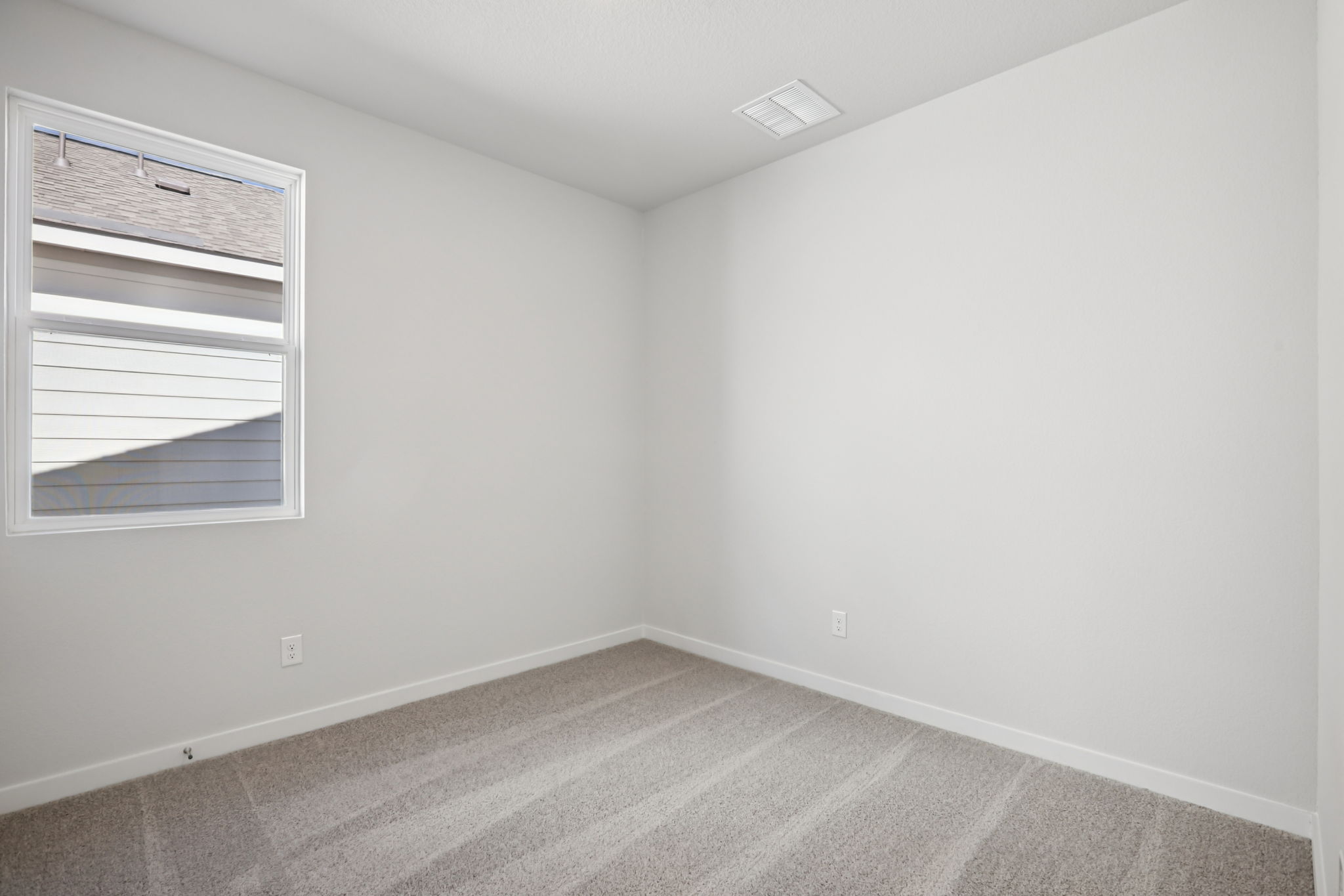 A room with a window and a rug.