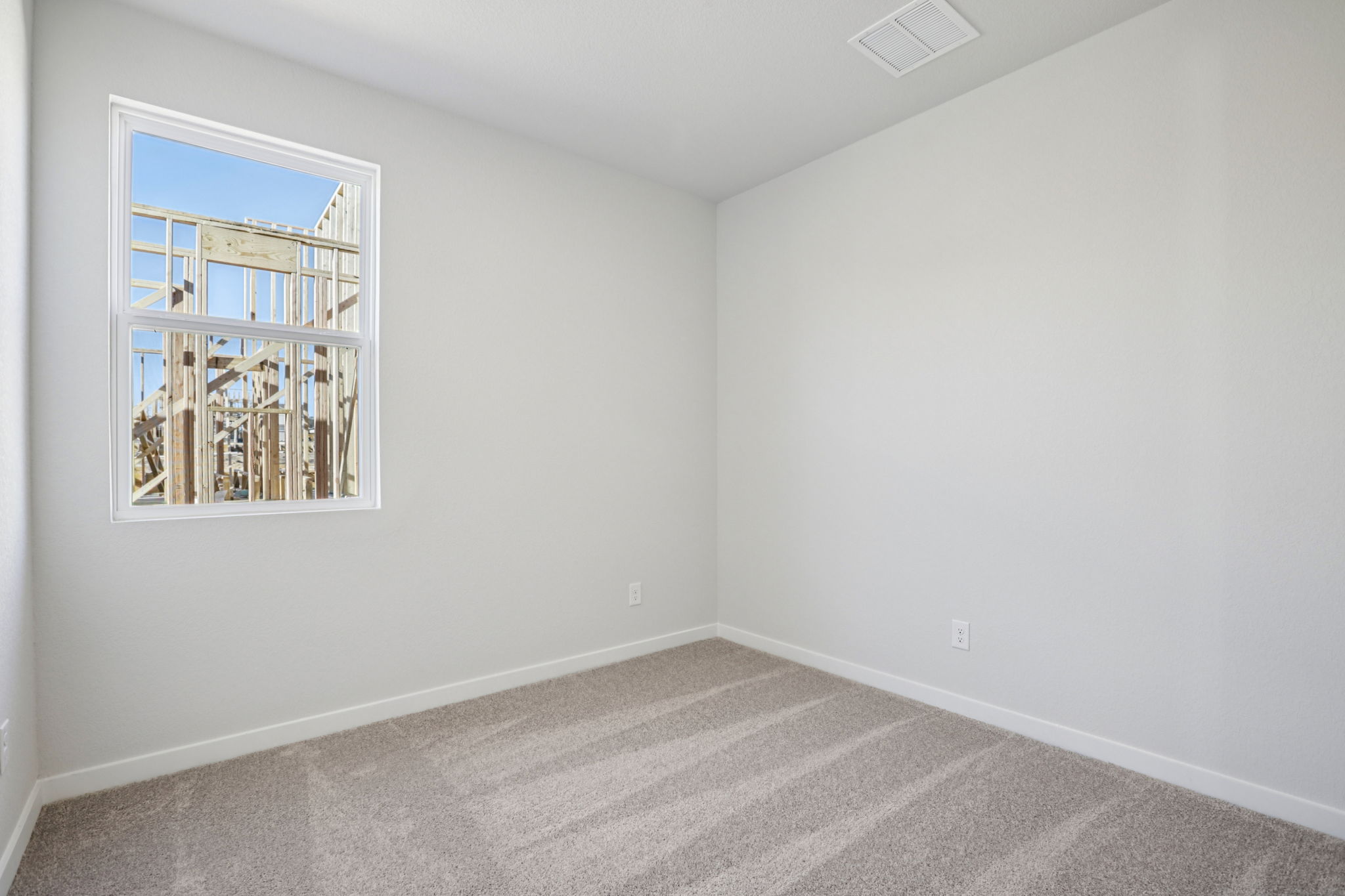 A room with a window and a rug.