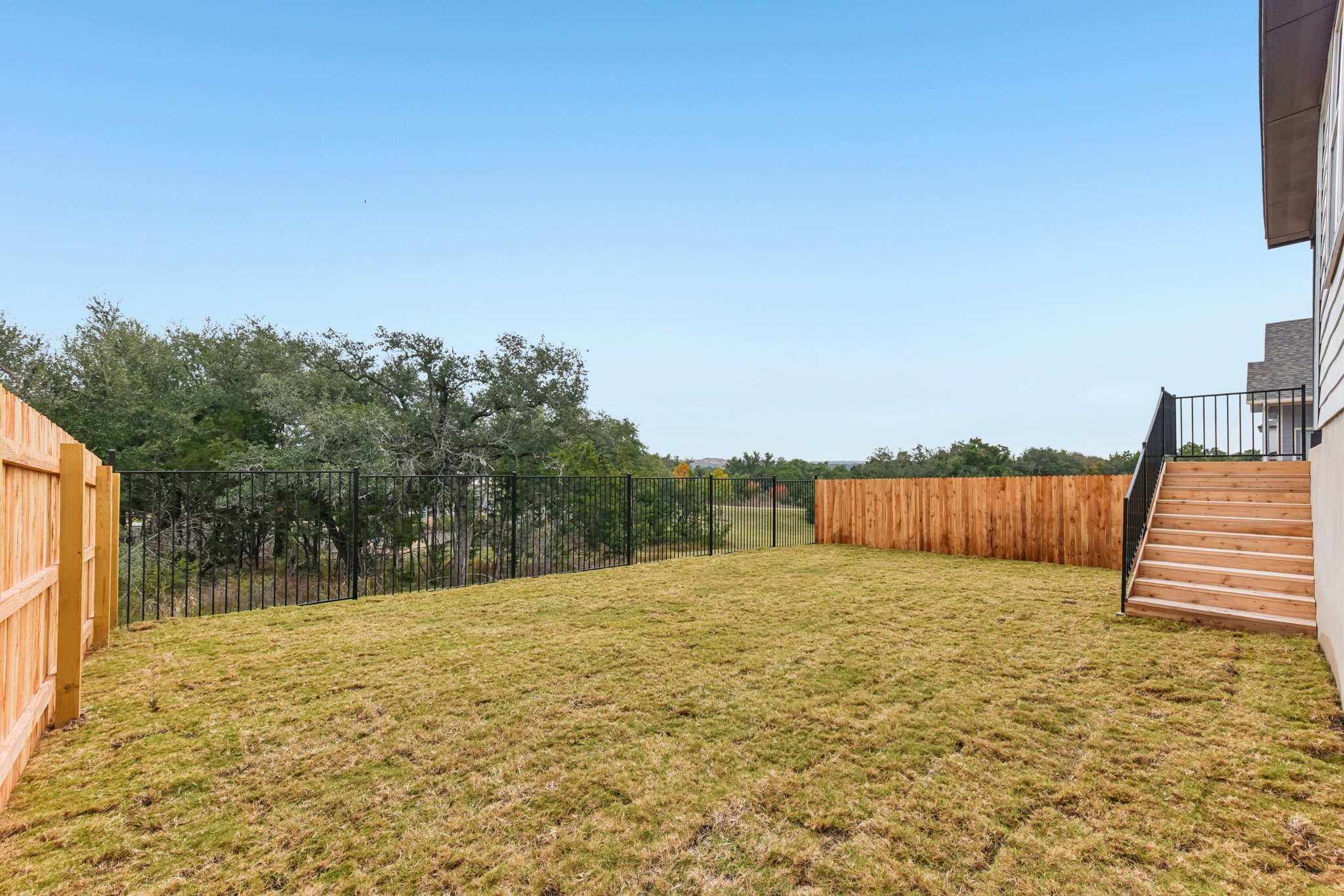 A fenced in yard with trees.