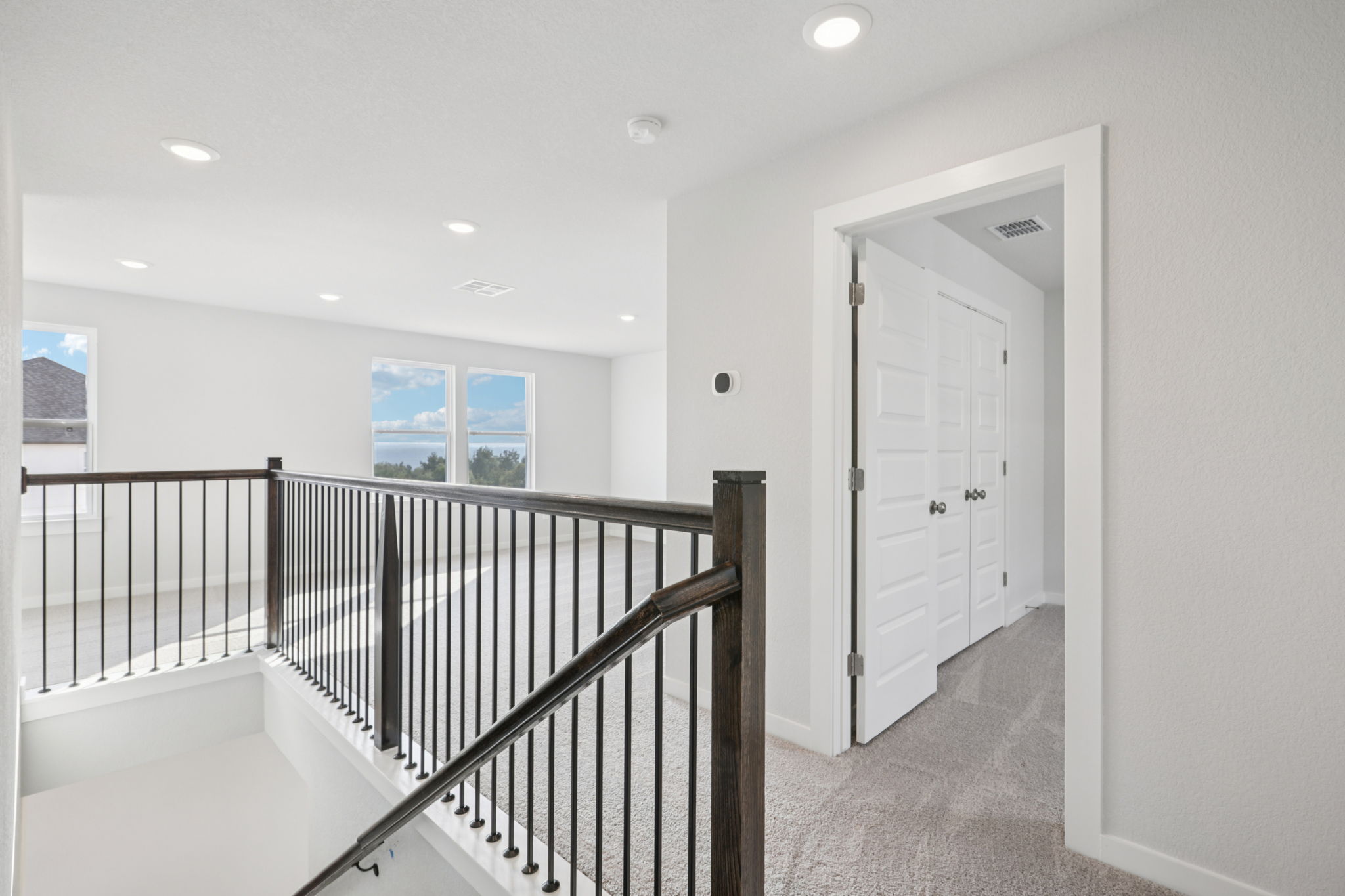 A white room with a black railing.