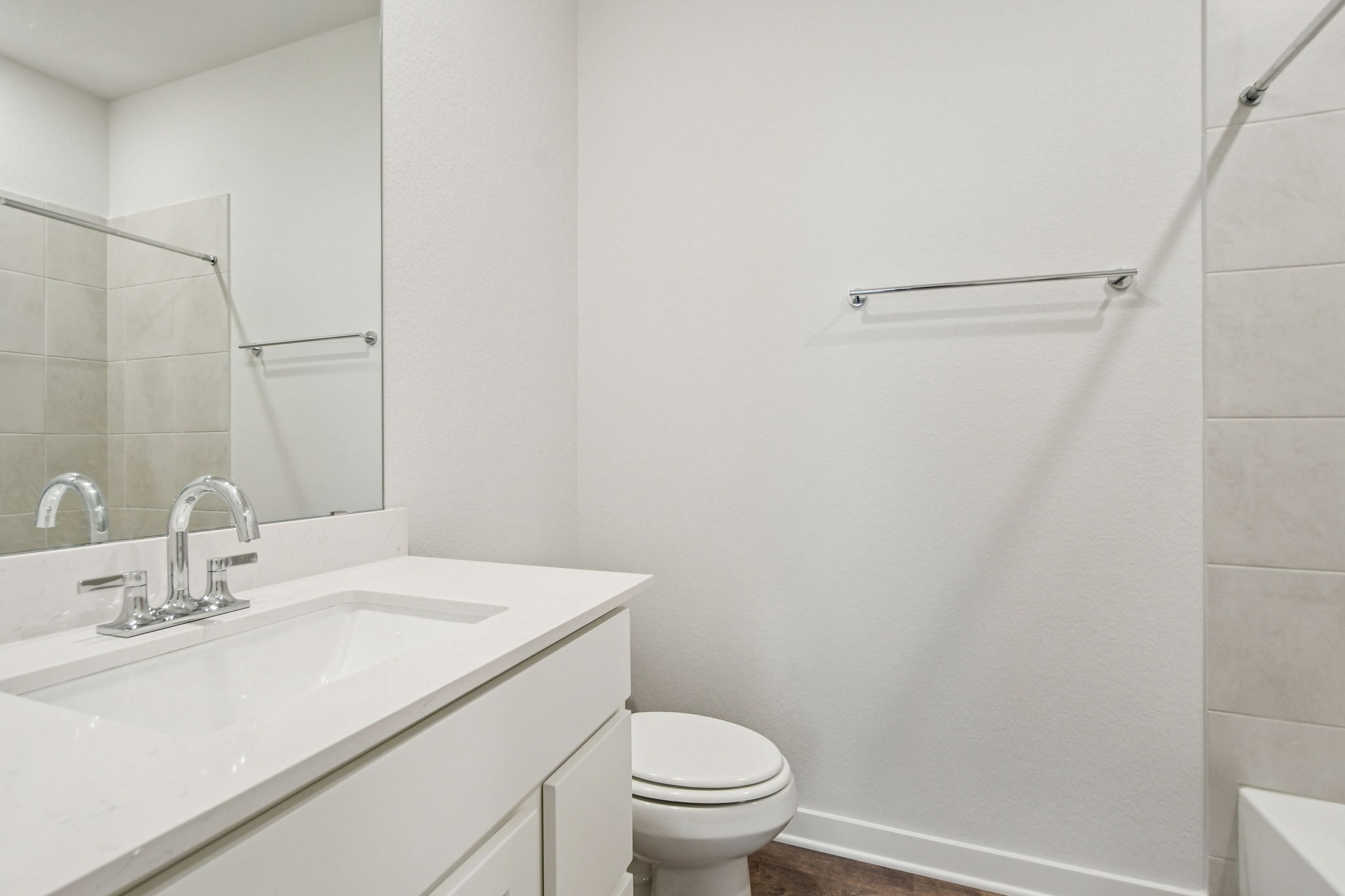 A bathroom with a sink toilet and mirror.