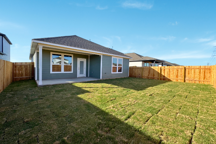 A house with a fence and grass.