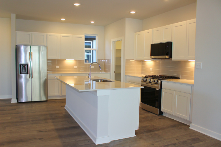 A kitchen with white cabinets.