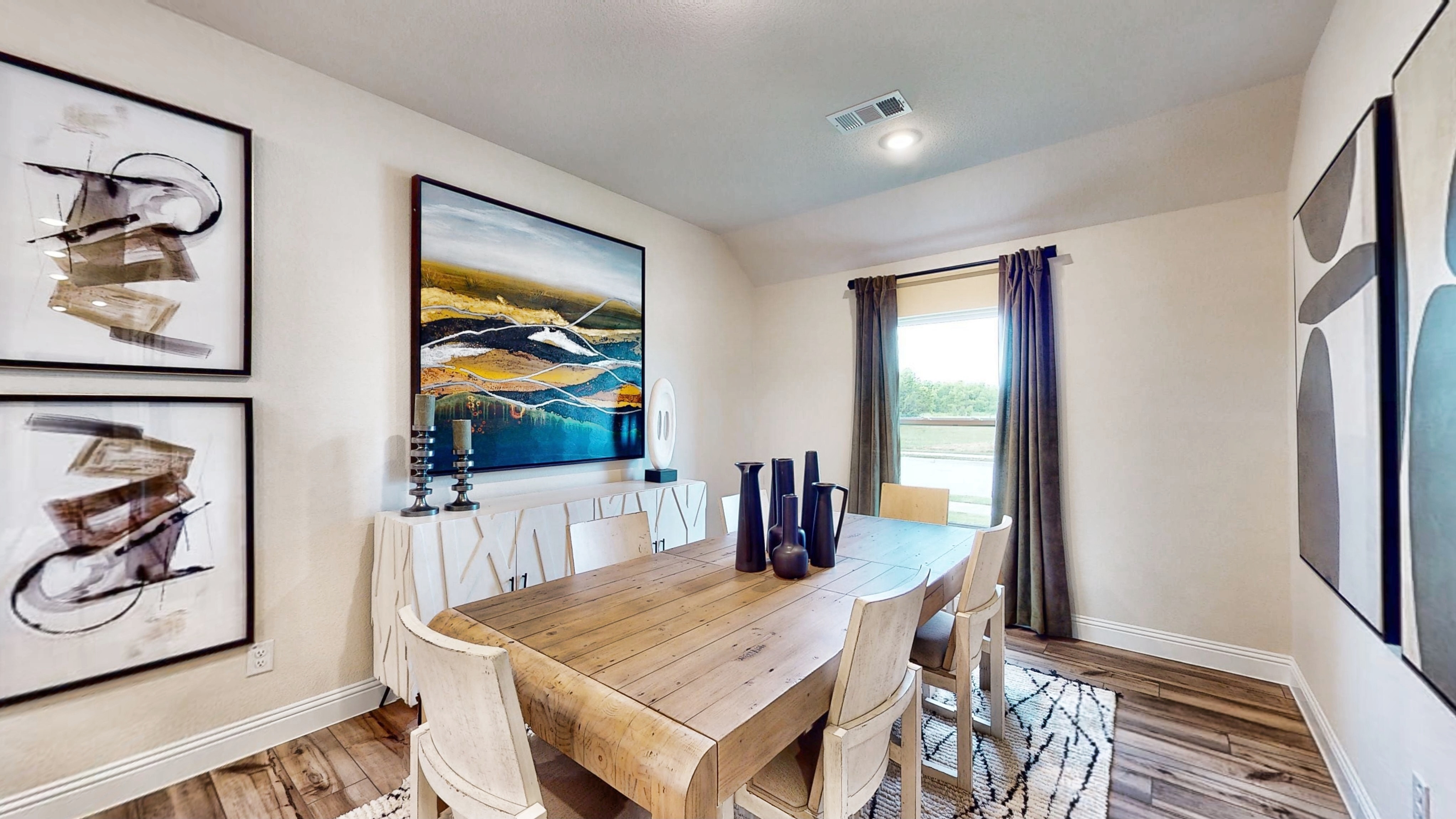 A dining room with a large painting on the wall.