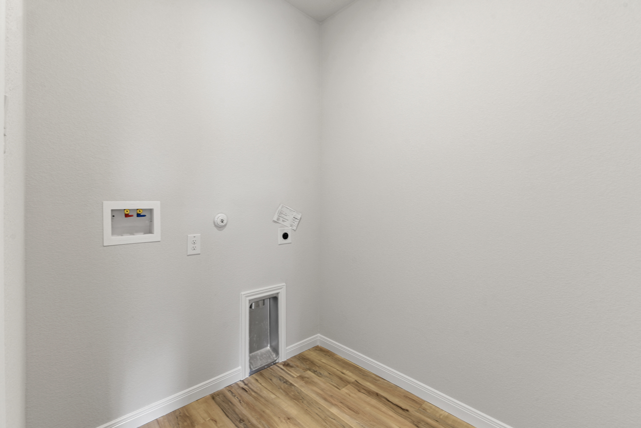 A room with a wood floor and white walls.