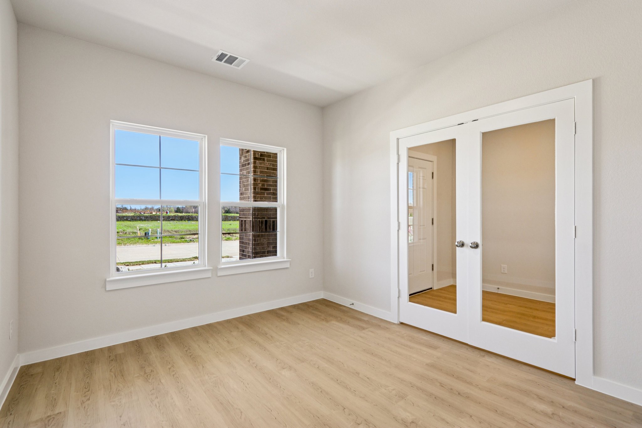 A room with a wood floor and a window.