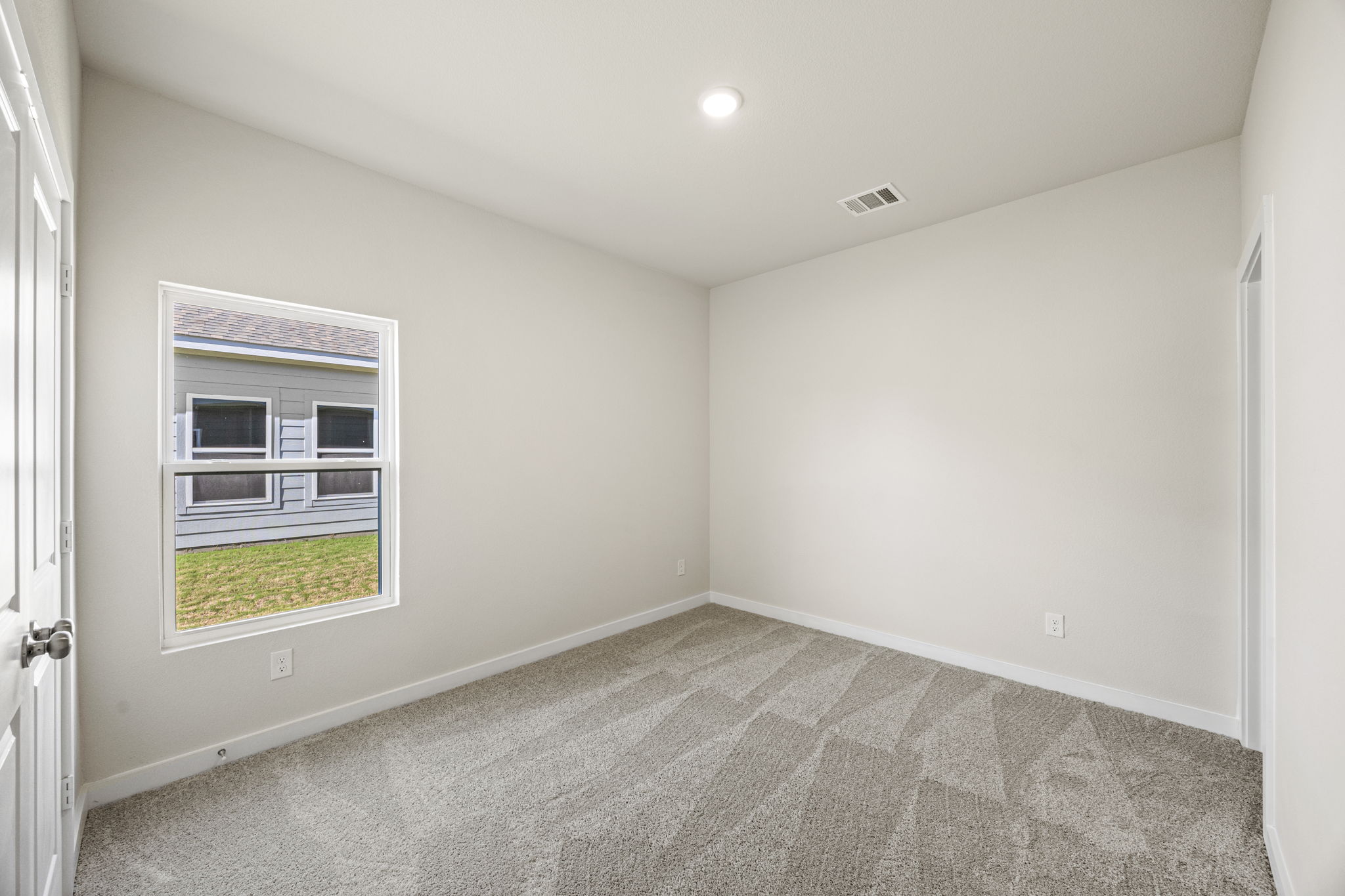 A room with a carpet and a window.