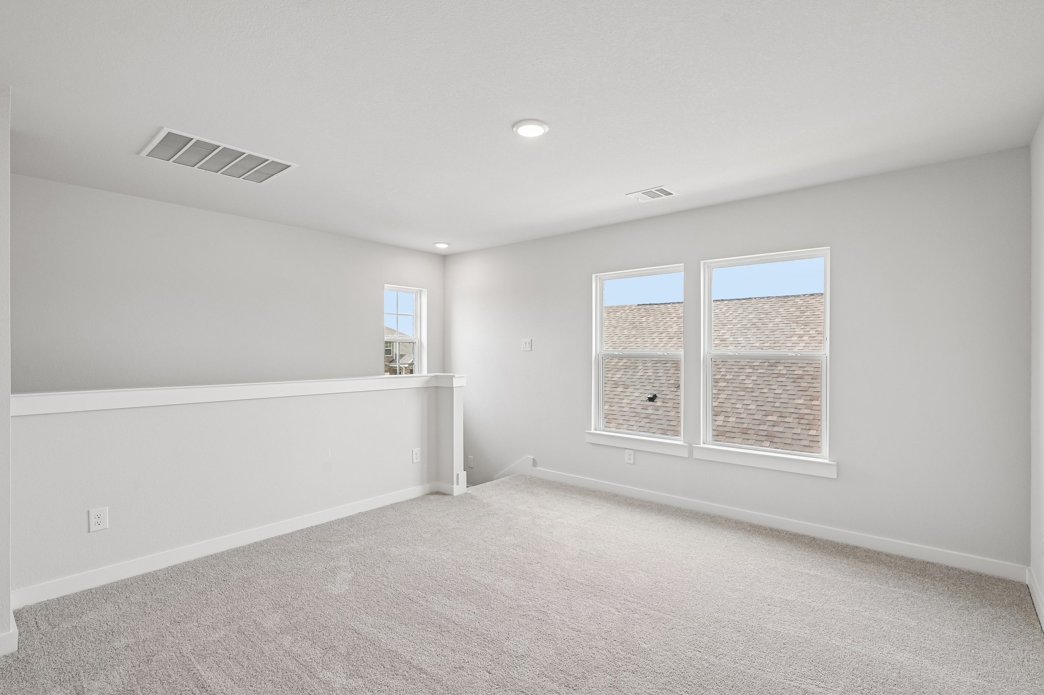 A room with a white wall and windows.