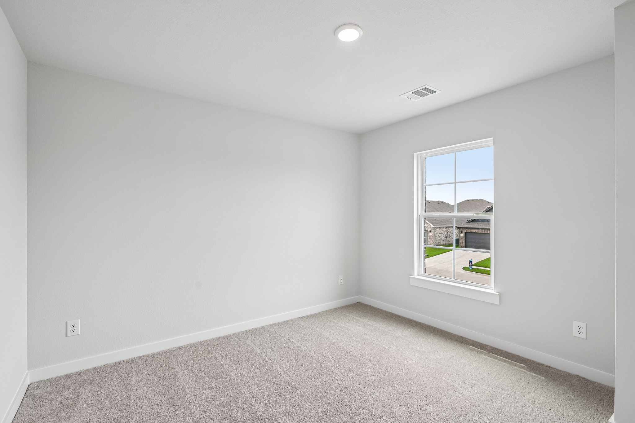 A room with a window and a carpet.