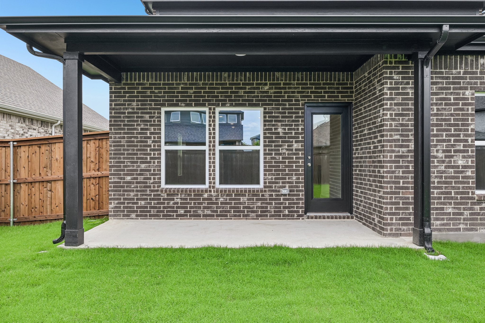 A brick building with a grass yard.